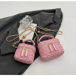 Vue détaillée du mini sac en tweed rose avec chaîne dorée et boule en métal ajustable