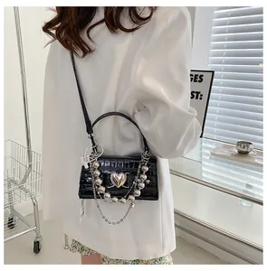 Détail du mini sac noir effet croco avec fermoir cœur et grosses chaînes argentées