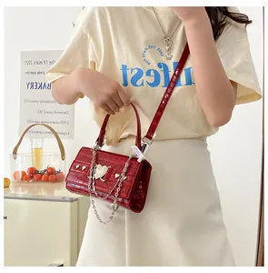 Détail du petit sac rouge motif crocodile avec chaîne coeur en métal et poignée fixe