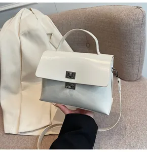 Detail of cream-white leather handbag with silver twist lock and elegant texture
