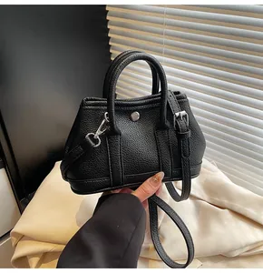 Detalle del mini bolso bandolera negro con textura de lichi premium y herrajes de metal plateado
