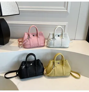 Detalle de cuatro bolsos de cuero con patrón de lichi y decoración de anillo metálico