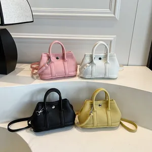 Mini bolso de mano elegante en cuatro colores con hebilla redonda y asas superiores