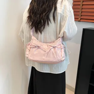 Sac à bandoulière bouffant en nylon rose avec nœuds et détails de cordon latéral