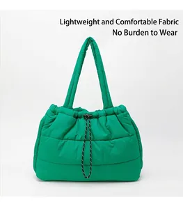 Detail of emerald green quilted tote bag with drawstring closure and soft padded handles
