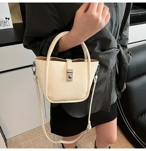 Détail du sac seau blanc cassé avec texture litchi et fermoir en métal argenté