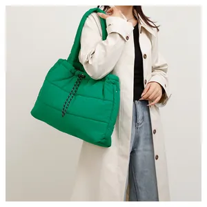 Detalle del bolso tote acolchado verde brillante con cordón de ajuste blanco y negro