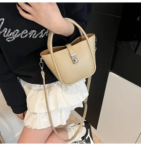 Détail d'un sac seau beige en cuir grainé avec boucle en métal argenté et bandoulière