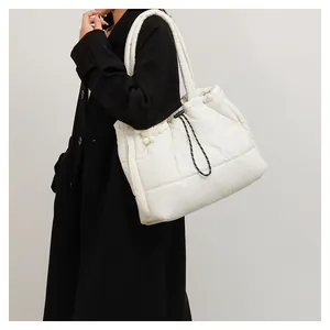 Detalle del bolso acolchado blanco crema con textura suave y práctico cierre de cordón
