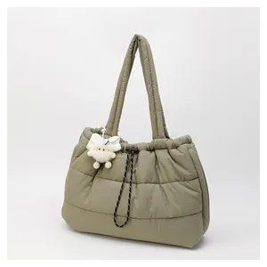 Detalle de bolso tote acolchado oliva con cordón ajustable y colgante de oveja de peluche