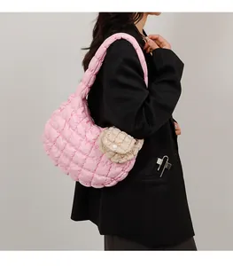 Close-up of pink quilted puffer shoulder bag with mini round pouch detail on a model
