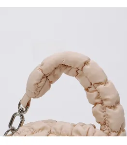 Close-up of soft pleated cloud bag detail with fluffy handle and silver metal hook