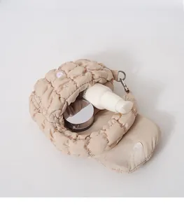 Mini beige quilted cloud bag interior view showing space for makeup and metal hook