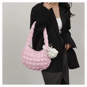 Detailed shot of pink quilted cloud bag featuring white mini coin purse and pleated texture