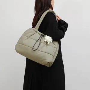 Bolso tote acolchado en verde oliva con cordón ajustable mostrado en el modelo