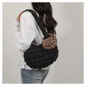 Detail of black quilted cloud bag with leopard print mini pouch and padded strap
