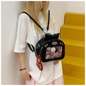 Detail of a black Ita bag featuring a transparent display window with anime badges