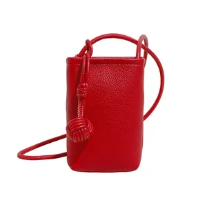 Mini red litchi leather bucket bag for phone with decorative knot and thin strap
