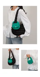 Detail of black quilted cloud bag with green mini pouch showing texture and styling
