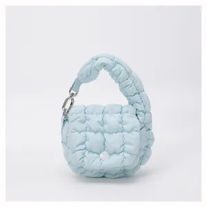 Detail of light blue quilted mini cloud bag with soft puff texture and metallic silver chain