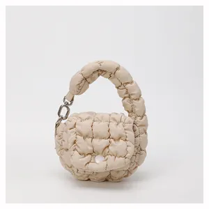 Detail of beige quilted cloud pouch with bubble texture and silver metal hardware hook