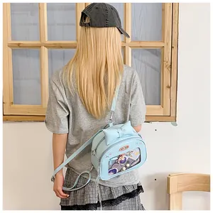 Detail of light blue ITA bag featuring a transparent display window and bow decoration