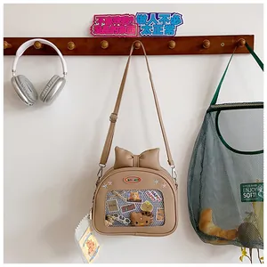 Detail of cute beige JK bow bag featuring a clear window for displaying small plush toys