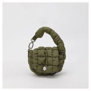 Detail of olive green quilted cloud bag featuring puffy texture and silver metal clasp
