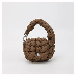 Detail of coffee brown quilted mini cloud bag with plush texture and white button
