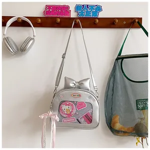 Detail of silver ita bag showing transparent window with Hello Kitty badges and bow