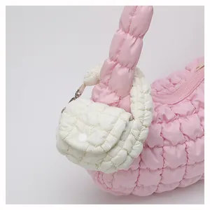 Close-up of quilted cloud mini bag featuring light pink nylon fabric and padded details