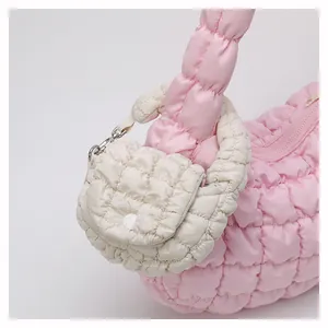 Detail of pink quilted cloud bag with cream mini pouch showing puffy nylon texture