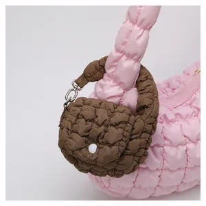 Detail of pink puffer mini bag and brown coin purse charm with quilted texture