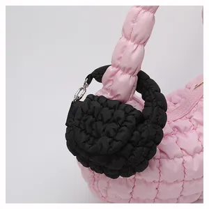 Macro detail of pink quilted bubble fabric handbag with black mini coin purse attachment