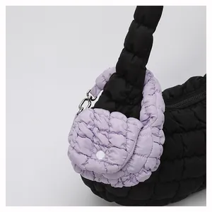 Detail of black quilted cloud bag texture with a purple mini coin purse attachment