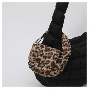 Detail of black quilted handbag featuring a leopard print mini pouch and silver metal buckle