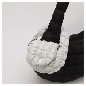 Detail of black quilted cloud bag with a mini white detachable coin purse and silver hook
