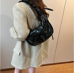 Borsa a spalla a mezzaluna nera lucida con fiocco e tracolla a pieghe stile vintage