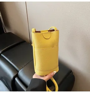 Macro detail of yellow pebbled leather phone bag showing back card slot and slim strap