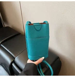 Detail of the mint green pebble leather crossbody phone bag with front pocket flap