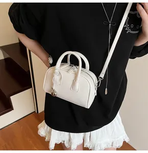 Close-up of white lychee grain leather mini bag with silver ball charm on model