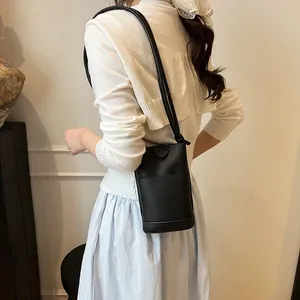 Chic black litchi grain leather crossbody bucket bag with slender shoulder strap