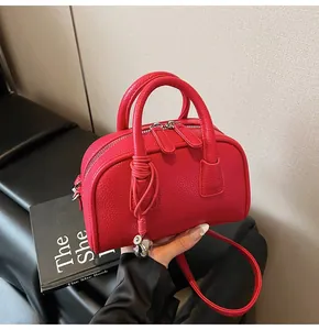 Detailed close-up of fuchsia lychee pattern leather handbag with silver double zippers