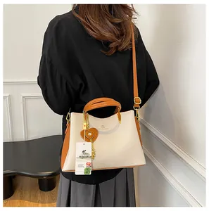 Model back view showing scale of large leather handbag with heart hardware charm