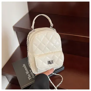 Dettaglio zaino trapuntato beige con chiusura a scatto argento e tracolla a catena