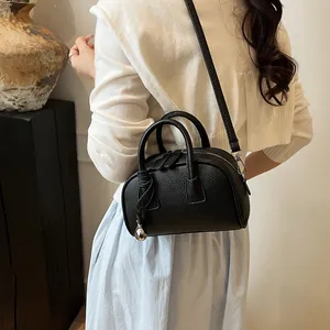 Minimalist black pebbled leather handbag with double handles and silver ball charm detail