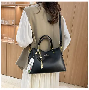 Detail of elegant black leather handbag featuring golden kangaroo logo and tassel charm