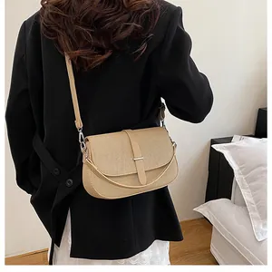Detail shot of beige textured crossbody bag showing the flap design and strap on model