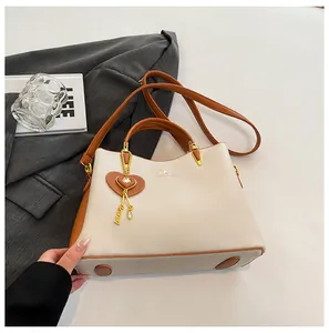 Detail of soft leather tote bag with heart charm and protective metal base feet