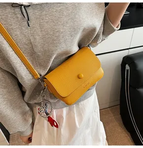 Détail du sac bandoulière jaune grainé avec un pendentif lapin mignon accessoire